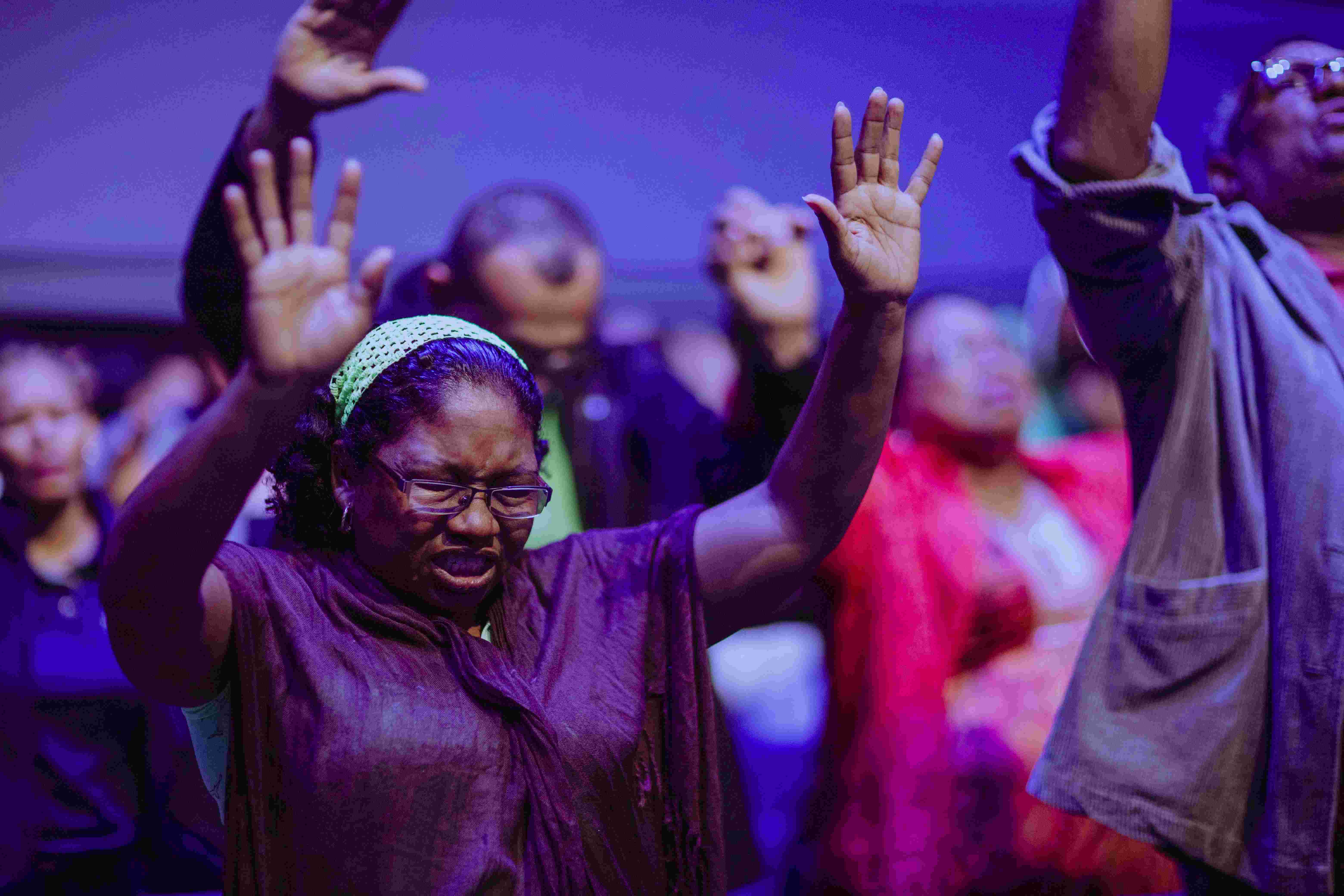 Parishioners raising their hands in prayer during worship